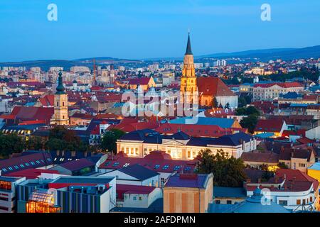 Vue aérienne de la vieille ville de Cluj Napoca avec les clochers de l'église Saint-Michel et de l'église franciscaine au coucher du soleil. La Roumanie. Banque D'Images