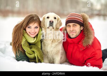 jeune couple avec un chien sur une promenade d'hiver. homme et femme avec labrador à l'extérieur. Banque D'Images