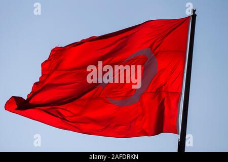 Près d'un drapeau turc, rouge, sous le soleil du soir. Banque D'Images