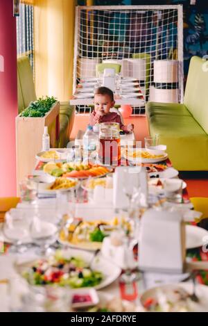 Petite fille en rose dans une chaise en face de big fest à table d'anniversaire Banque D'Images