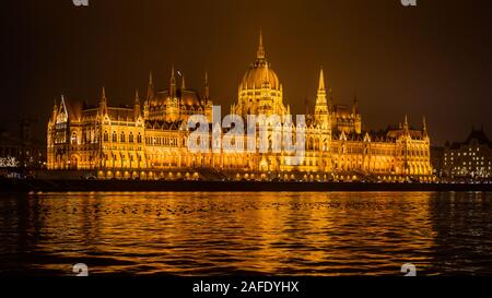 Le Parlement hongrois, qui s'est doté d'un bâtiment sur le Danube à Budapest, est vu de nuit depuis un bateau touristique Banque D'Images