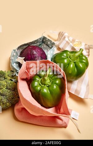 Des sacs en coton tissu à l'épicerie avec des légumes. Fond beige. Pas de plastique Banque D'Images