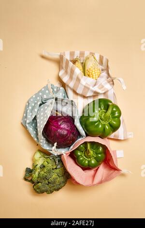 Des sacs en coton tissu à l'épicerie avec des légumes. Fond beige. Pas de plastique Banque D'Images