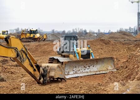 Pelle et d'un bulldozer qui travaillent sur un chantier de construction. Le défrichement des terres, le nivellement, l'excavation de bassin, de tranchées et de l'utilitaire foundation creuser. Pose d'u Banque D'Images