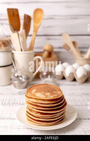 La cuisson des crêpes. Ingrédients, vaisselle et ustensiles de cuisine pour des crêpes. Focus sélectif. Banque D'Images