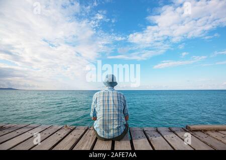 Mer Man relaxing on pier Banque D'Images