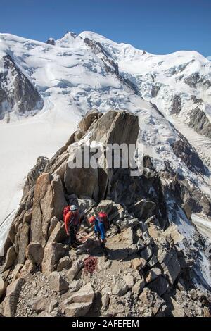 Deux alpinistes grimper à côté de l'Aiguille du Midi La plate-forme avec le Mont Blanc en arrière-plan. Chamonix. France Banque D'Images