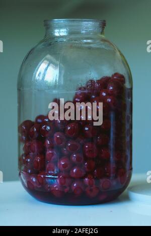 Impression photo d'une trois litres bocal rempli d'alcool imbibé de jus de cerises préparé pour appuyer sur Banque D'Images