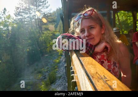 Femme à la fenêtre d'un train et lors d'un voyage - Sarganska osmica Banque D'Images