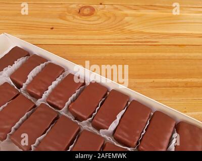 Assortiment de chocolats doux dans une boîte sur fond de bois Banque D'Images