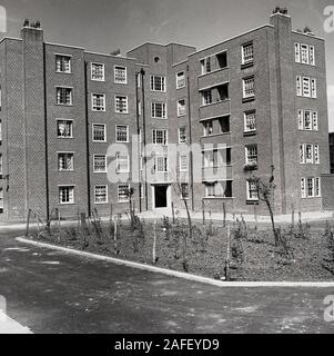 Années 1950, historiques, après-guerre et récemment construit en brique, blocs d'appartements ou maisonnettes, Londres, Angleterre, Royaume-Uni. Construit par les autorités locales pour loger les travailleurs locaux, ces unités de niveau relativement bas ont été construites en utilisant les méthodes traditionnelles de la construction, et sont typiques du style architectural de l'immédiat après-guerre, avant que la tour construite en béton blocs tour du mouvement "moderne" de la décennie suivante. Banque D'Images