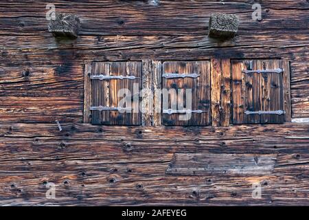 Trois fenêtres avec volets fermés sur une vieille maison de ferme Suisse Banque D'Images