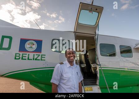 Orange Walk, Belize - 16 novembre, 2019. Le capitaine de la Maya Island Air ouvre la porte de son avion à l'escale à Orange Walk au milieu de sucre Banque D'Images