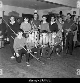 Historique des années 1960, à l'intérieur d'une salle, de jeunes membres d'un club de tir à l'arc se sont réunis avec leurs arcs pour une photo de groupe, Angleterre, Royaume-Uni. Banque D'Images