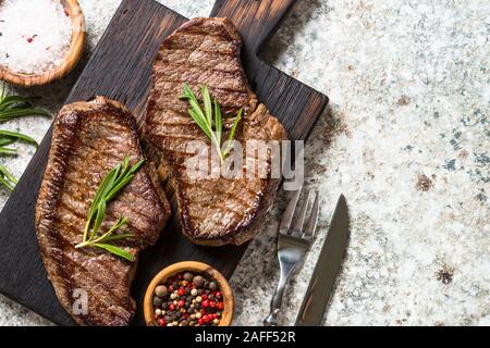 Pavé de boeuf grillé sur planche à découper en bois. Banque D'Images