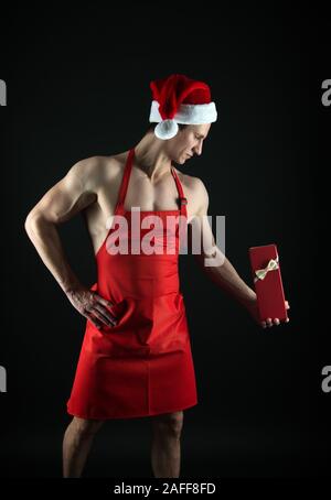 Meilleur cadeau de Noël pour la remise en forme, bien-être et les amateurs de sport. Homme fort tenir boîte-cadeau. Athletic cook avec cadeau de Noël. Fête de Saint Nicolas. Boxing day. Nouvelle année présents. Cadeau du père Noël. Banque D'Images