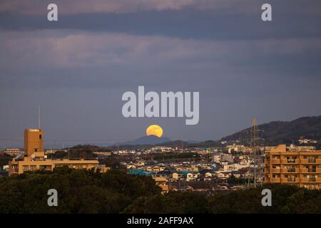 Pleine lune se lève sur la montagne lointaine dans les petites ville japonaise au crépuscule Banque D'Images