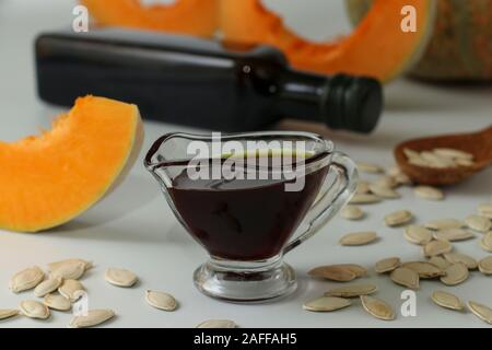 L'huile de citrouille en saucière et dans une bouteille sur un fond blanc, l'orientation horizontale Banque D'Images