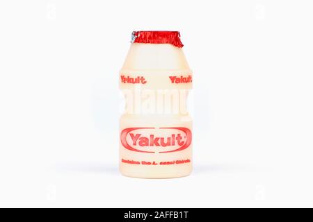 Une petite bouteille de boisson de lait probiotique sucré Yakult tourné sur un fond blanc. Banque D'Images