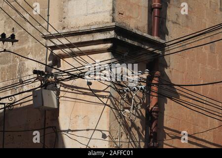 Les câbles électriques en désordre sur le coin de mur à Malte Banque D'Images