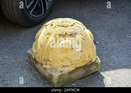 Élément de design et la protection de trottoir parking et détail de la roue de voiture. Limiteur d'hémisphère en relief jaune parking pour voitures on city Street Banque D'Images