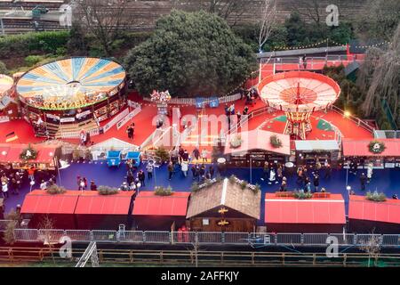 Un portrait d'une petite partie d'Édimbourg Noël dans l'Est des jardins de Princes Street dans le centre-ville d'Édimbourg. Les principales lignes de chemin de fer sont à l'arrière-plan et l'image montre des expositions comme l'waltzers atrractions et chaise enfant-o-plans. Les visiteurs se promènent entre les manèges forains, et au premier plan sont quelques-unes des étals du marché de Noël. Banque D'Images