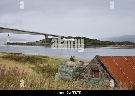 Pont au-dessus de la rivière reliant le village continental de Kyle de Lochalsh au village de Kyleakin sur Skye. Bâtiment de stockage de pierre sur la rive. Banque D'Images