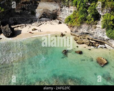 Vue aérienne d'une petite plage avec rock cliff à Bali. L'eau de mer avec de belles vagues pour le surf. Paysage de l'océan, destination de vacances Banque D'Images