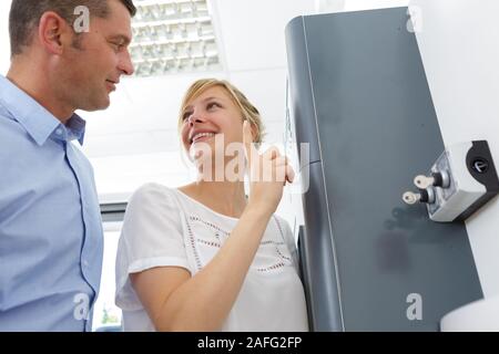 Femme montrant les clés dans les commutateurs de commande de collègue masculin Banque D'Images