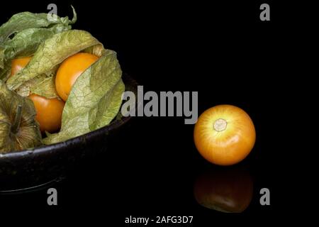 Beaucoup d'orange frais entier physalis En vitrage isolé sur bol en verre noir Banque D'Images