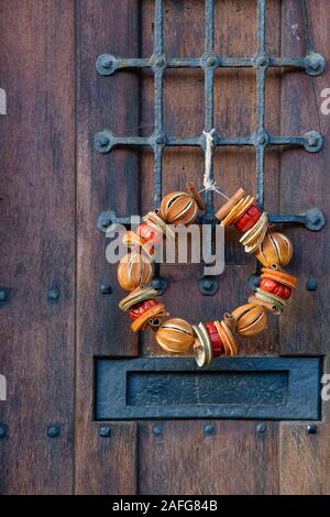 Couronne de Noël sur une vieille porte en bois à Chipping Campden, Cotswolds, Gloucestershire, Angleterre Banque D'Images