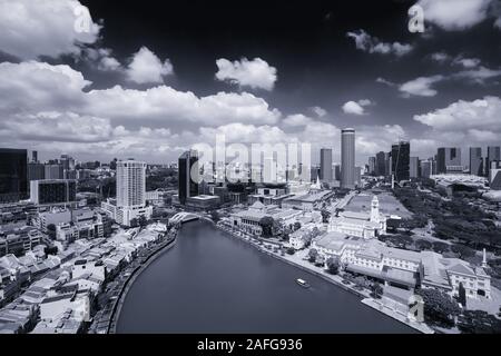 Vue aérienne de la ligne d'horizon du paysage urbain dans le ton artistique noir et blanc. Largeur des rives du fleuve Singapour et un bateau fluvial qui transportent les touristes pour le tourisme Banque D'Images