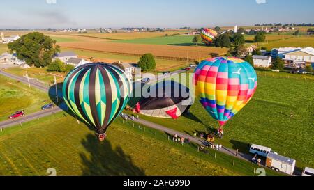 Ballons à air chaud s'élever dans l'air au-dessus de la campagne américaine en Pennsylvanie, plusieurs dirigeables aéroporté se préparent à commencer tôt le matin Banque D'Images