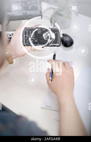 Photo de l'homme tenant un smartphone et un stylo dans les mains. Isolé sur un fond blanc. Banque D'Images