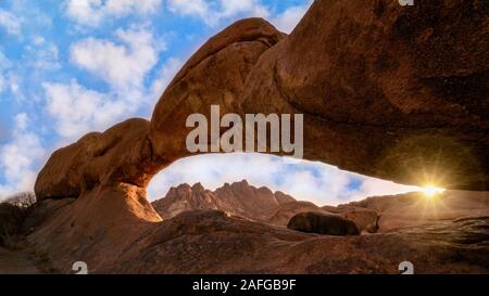 Ancienne roche de granit formant une arche naturelle dans le désert du Namib, à l'aube. Dans Spitzkoppe, la Namibie. Banque D'Images