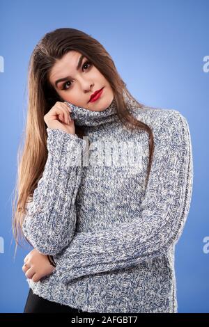 Sad young woman against blue background Banque D'Images