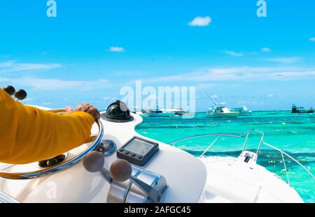 Part du capitaine sur volant de bateau à moteur dans l'océan bleu durant la journée de la pêche. Pêche succès concept. Yacht Ocean Banque D'Images