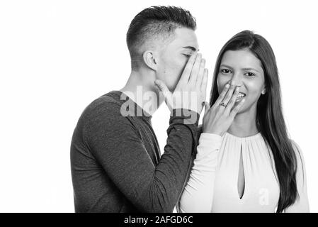 Heureux couple smiling while man whispering to woman Banque D'Images