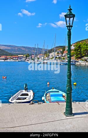 Une magnifique vue sur la baie abritée vers le joli village de Agia Effimia, avec yachts amarrés à quai et maisons colorées sur la colline. Banque D'Images