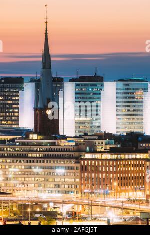 Stockholm, Suède. Fermer la vue de saint Clara ou Saint Klara Église et maisons au crépuscule le crépuscule des Lumières. Éclairage de nuit en soirée. Banque D'Images