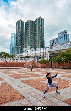 Asian woman practicing tai chi dans le parc de Kowloon dans la matinée. Tsim Sha Tsui, Kowloon, Hong Kong, Chine. Banque D'Images