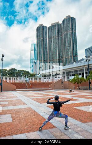 Asian woman practicing tai chi dans le parc de Kowloon dans la matinée. Tsim Sha Tsui, Kowloon, Hong Kong, Chine. Banque D'Images