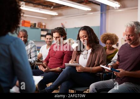 Groupe auteur de notes tout en assistant à la réunion de quartier dans le centre communautaire Banque D'Images