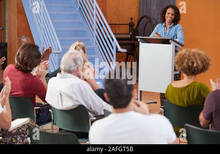 Femme à présider la réunion de quartier à Podium Centre communautaire Banque D'Images