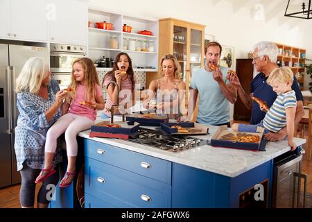 Multi Generation Family autour de l'île de cuisine pizzas à emporter Manger ensemble Banque D'Images