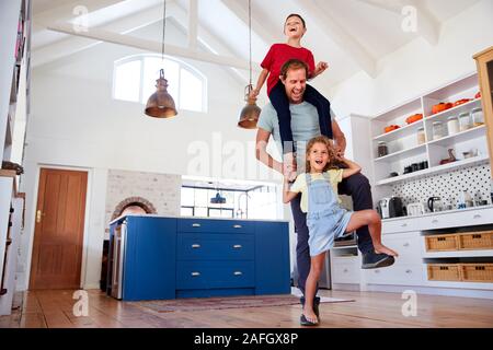 Jeu de fille marcher sur les pieds avec les Pères fils sur les épaules à la maison Banque D'Images