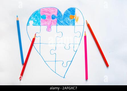 Enfant colorée appelée coeur avec jigsaw puzzle sur fond blanc comme un symbole de l'autisme. Banque D'Images