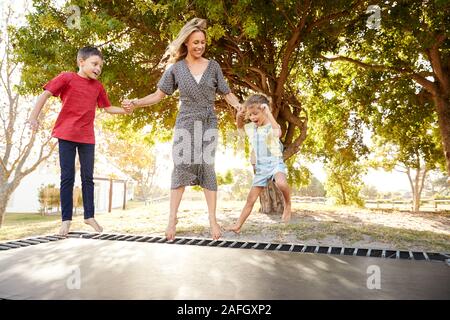 Mère jouant avec des enfants sur d'extérieur dans le jardin Banque D'Images