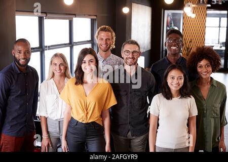 Portrait of a creative business team standing et souriant à la caméra dans leur bureau, elevated view Banque D'Images