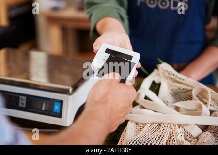 Le paiement sans contact en client pour faire des achats à la caisse de l'Épicerie Banque D'Images